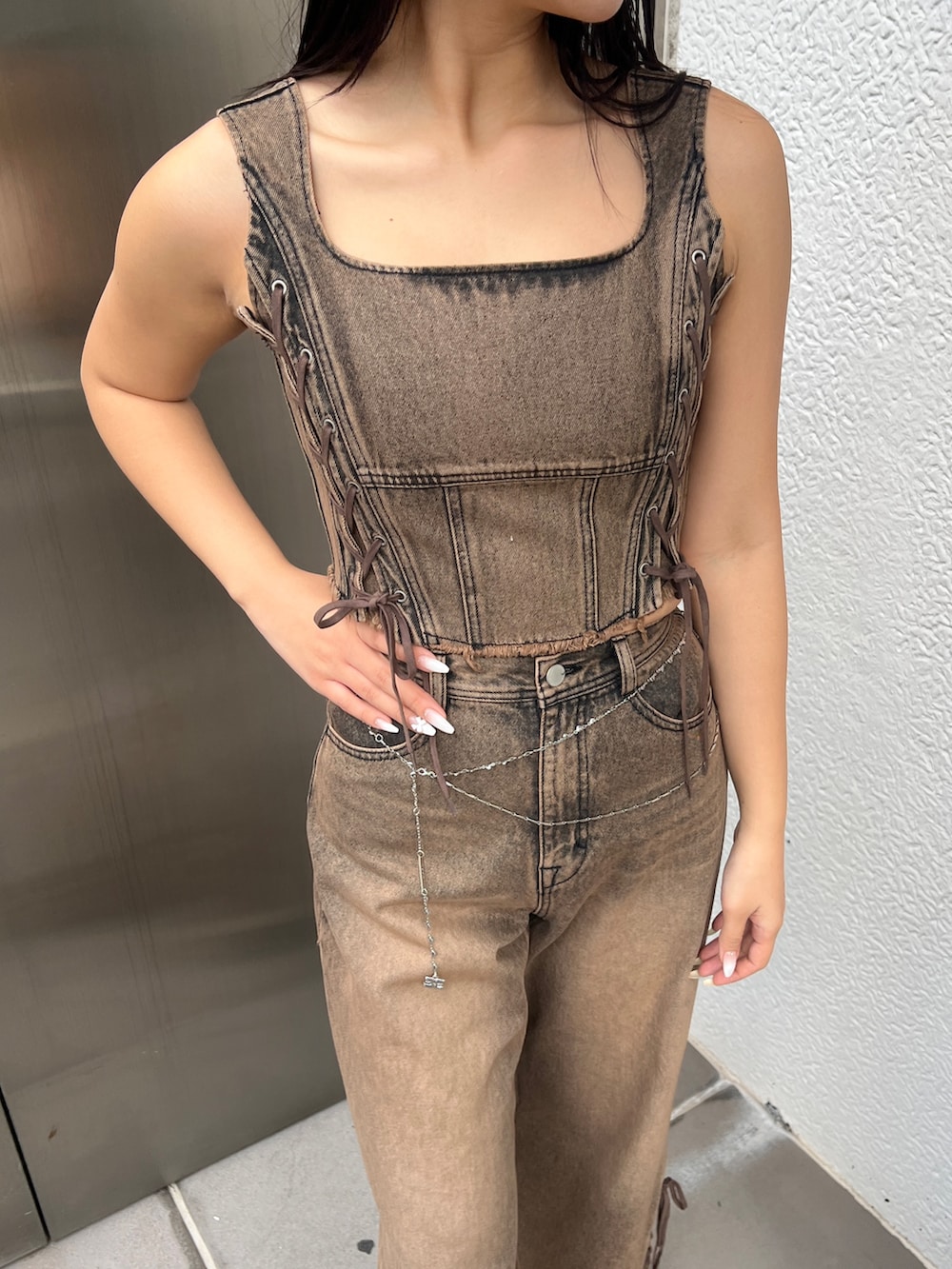 ブラウン系のタンクトップ、ブラウン系のデニムパンツ、ブラウン系のスニーカーを着用したレディースの春コーディネートの3枚目の写真