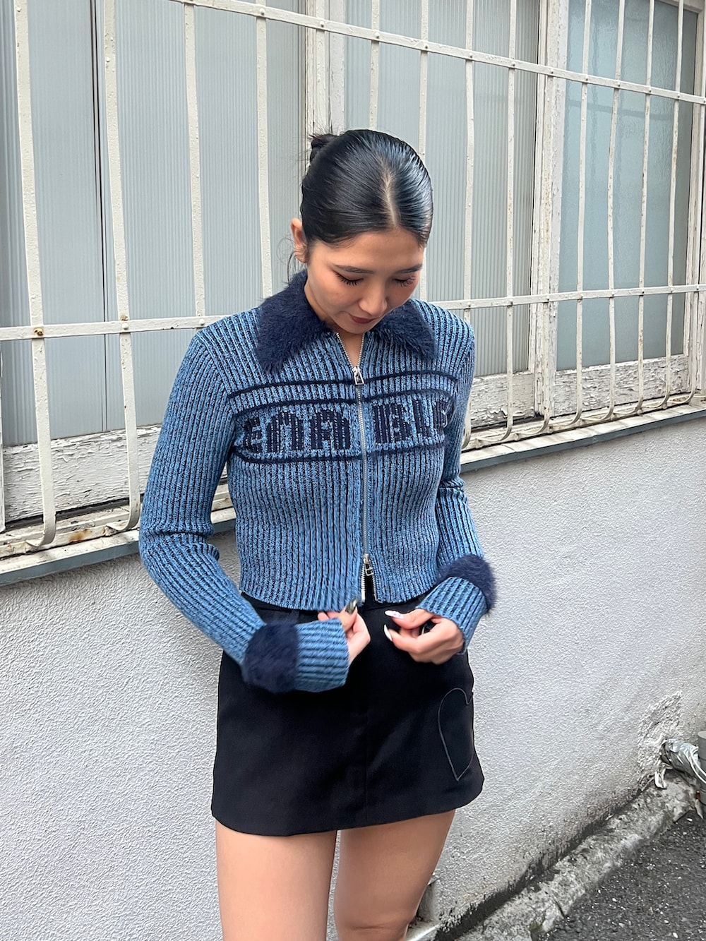 ブラック系のブルゾン、ブラック系のスカート、ブラック系のブーツを着用したレディースの冬コーディネートの3枚目の写真