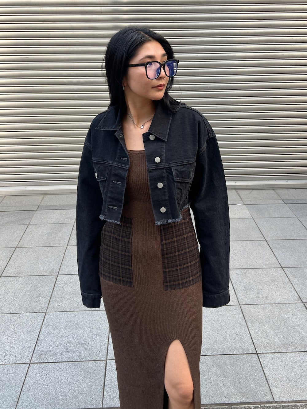 ブラック系のデニムジャケット、ブラウン系のワンピース、ブラック系のブーツを着用したレディースの夏コーディネートの3枚目の写真