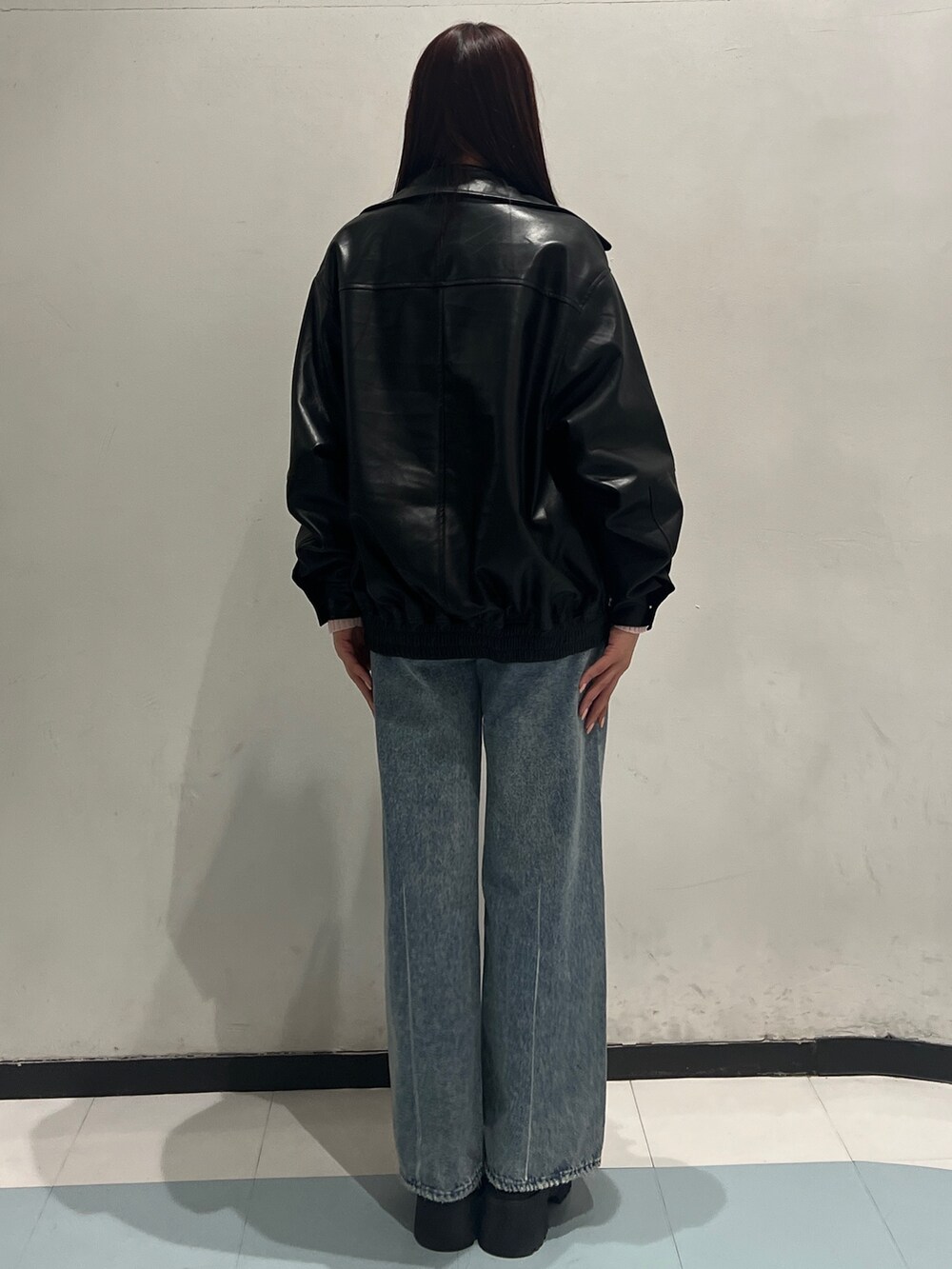 ピンク系のニット/セーター、ブラック系のブルゾン、ブルー系のデニムパンツを着用したレディースの冬コーディネートの3枚目の写真