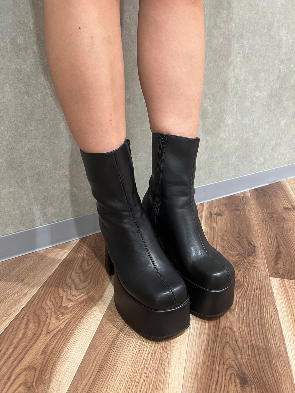 ブラック系のワンピース、ブラック系のTシャツ/カットソー、ブラック系のブーツを着用したレディースの秋コーディネートの7枚目の写真