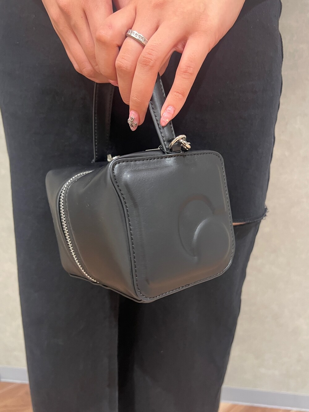 グレー系のタンクトップ、ブラック系のデニムスカート、ブラック系のハンドバッグを着用したレディースの夏コーディネートの8枚目の写真