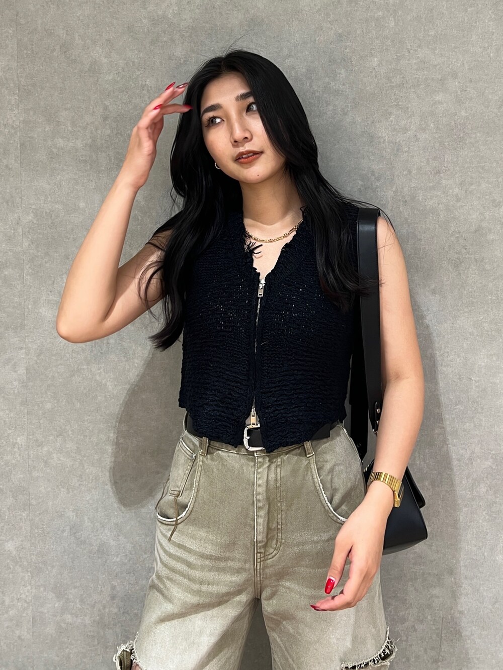 ブラック系のベスト、ホワイト系のニット/セーター、ベージュ系のデニムパンツを着用したレディースの夏コーディネートの8枚目の写真