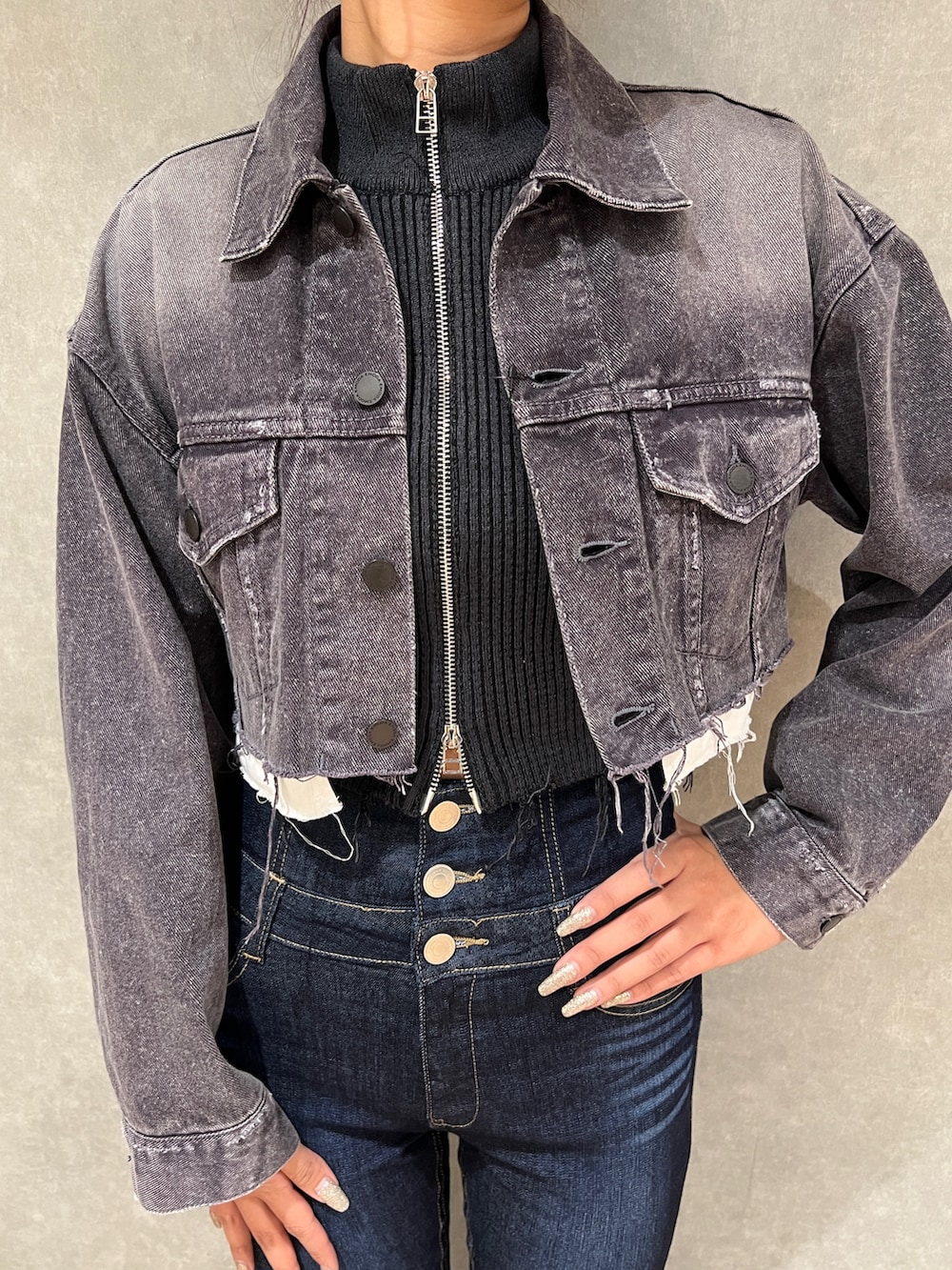 ブラック系のニット/セーター、ブラック系のデニムジャケット、ブルー系のデニムパンツを着用したレディースの秋コーディネートの5枚目の写真