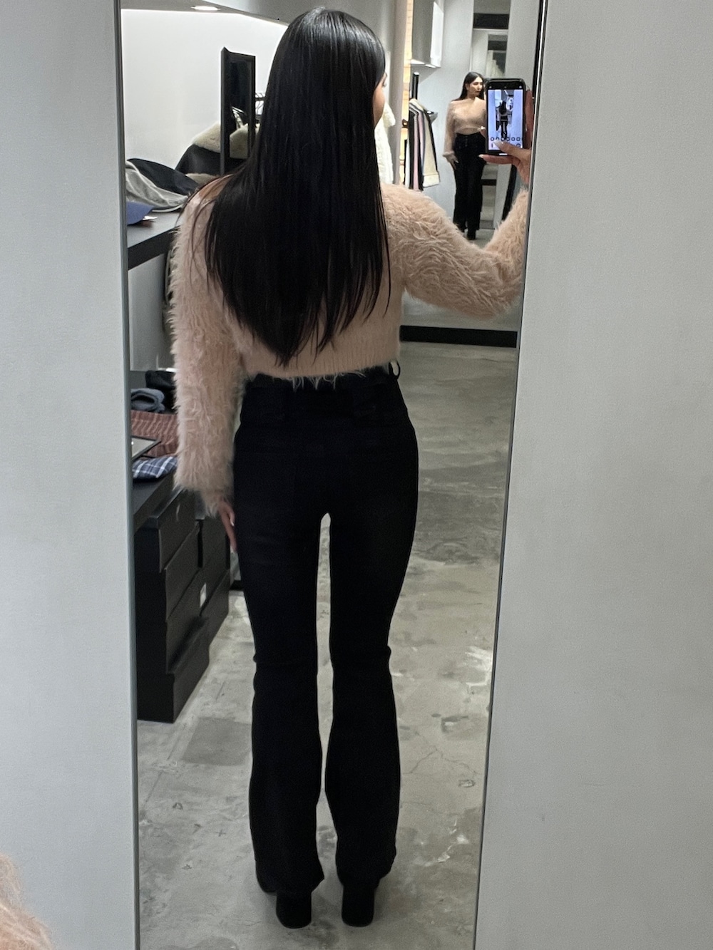 ピンク系のニット/セーター、ブラック系のデニムパンツ、ブラック系のブーツを着用したレディースの冬コーディネートの3枚目の写真