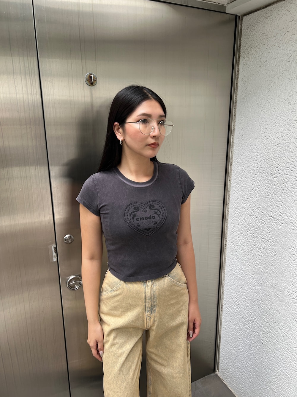 ブラック系のTシャツ/カットソー、ベージュ系のデニムパンツ、ブラック系のサンダルを着用したレディースの夏コーディネートの4枚目の写真