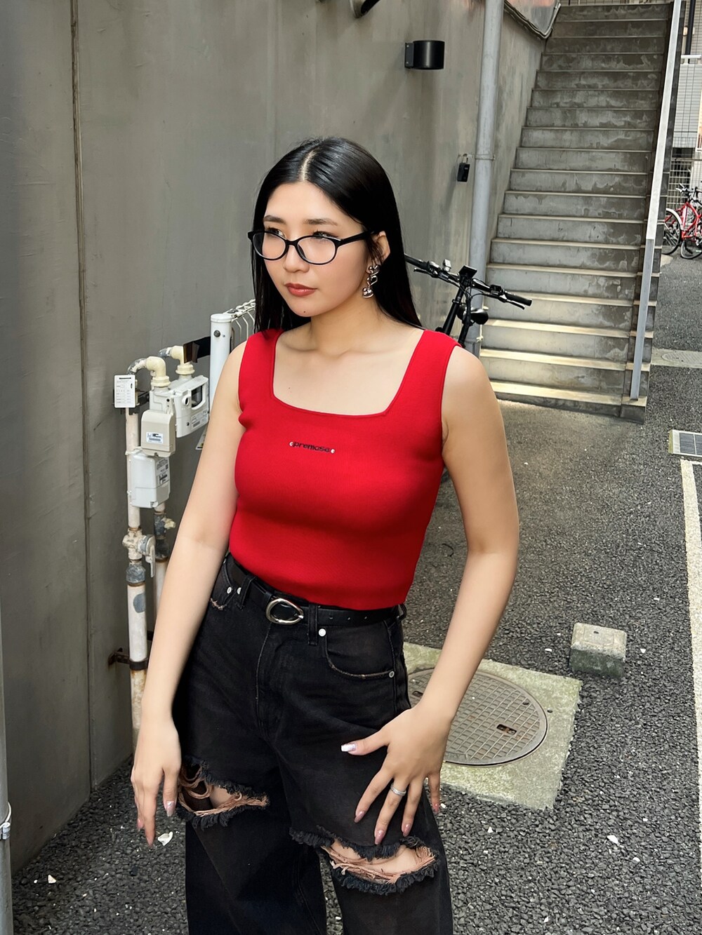 レッド系のTシャツ/カットソー、ブラック系のデニムパンツ、ブラック系のスニーカーを着用したレディースの夏コーディネートの4枚目の写真