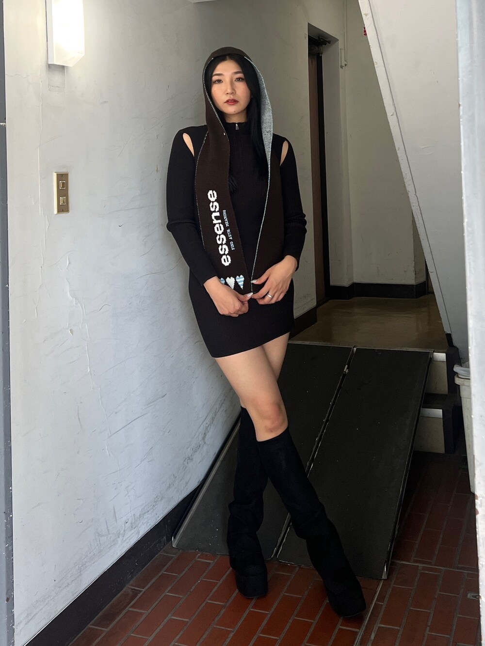 ブルー系のブルゾン、ブラウン系のワンピース、ブラック系のブーツを着用したレディースの夏コーディネートの3枚目の写真