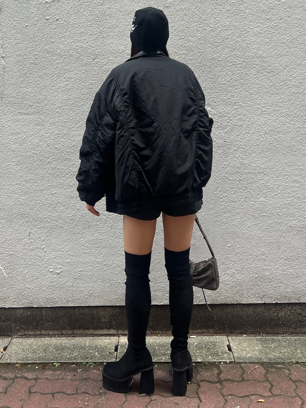 ホワイト系のキャミソール、ブラック系のブルゾン、ブラック系のその他パンツを着用したレディースの秋コーディネートの3枚目の写真