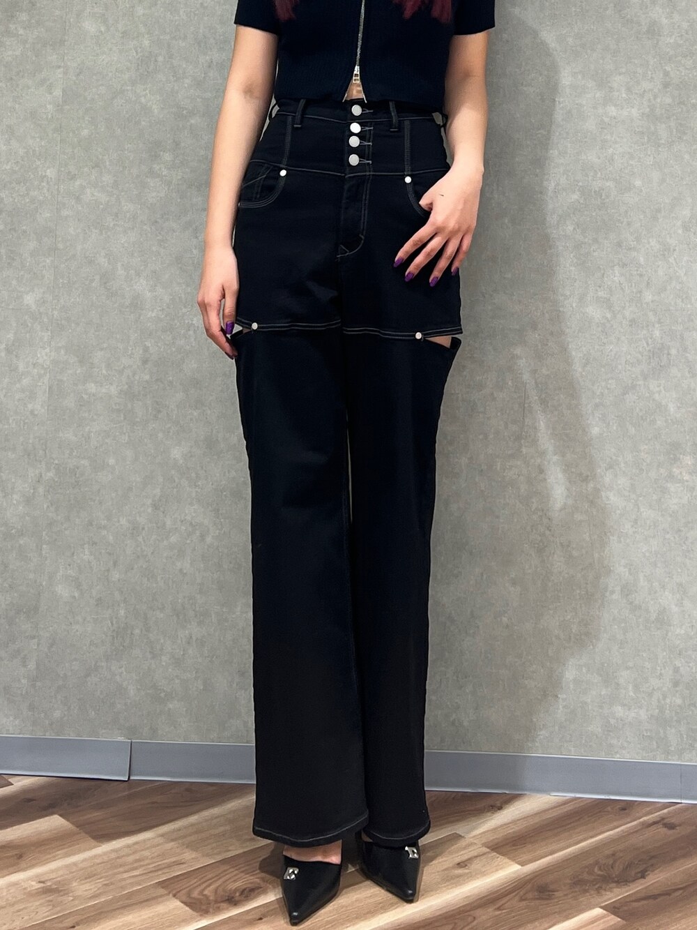 ブラック系のデニムパンツ、ブラック系のニット/セーター、ブラック系のパンプスを着用したレディースの春コーディネートの3枚目の写真