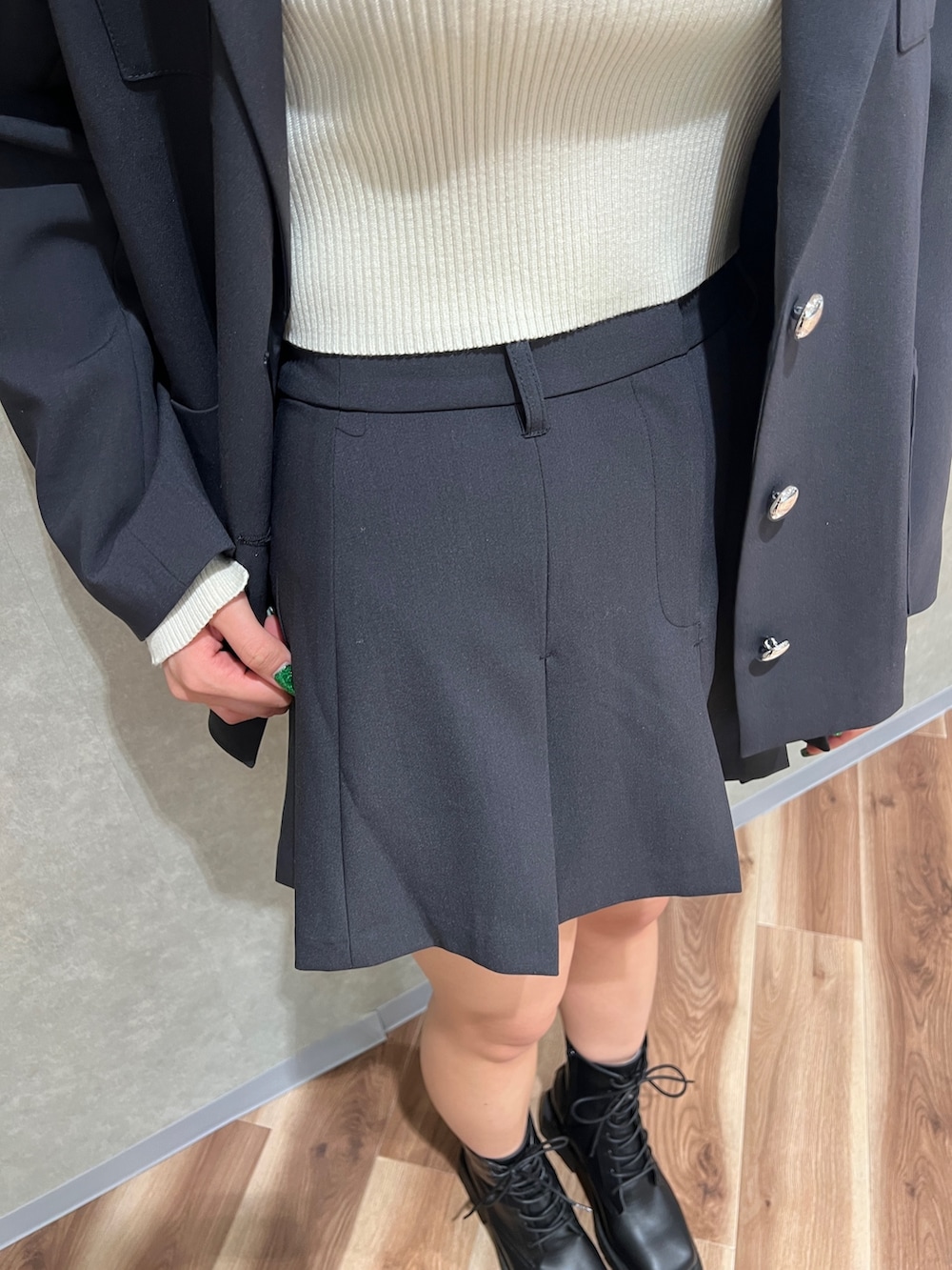 グレー系のテーラードジャケット、ホワイト系のニット/セーター、グレー系のスカートを着用したレディースの冬コーディネートの5枚目の写真