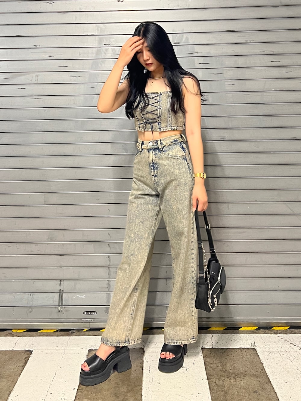 ベージュ系のデニムパンツ、ブラック系のハンドバッグ、ブラック系のサンダルを着用したレディースの夏コーディネートの3枚目の写真