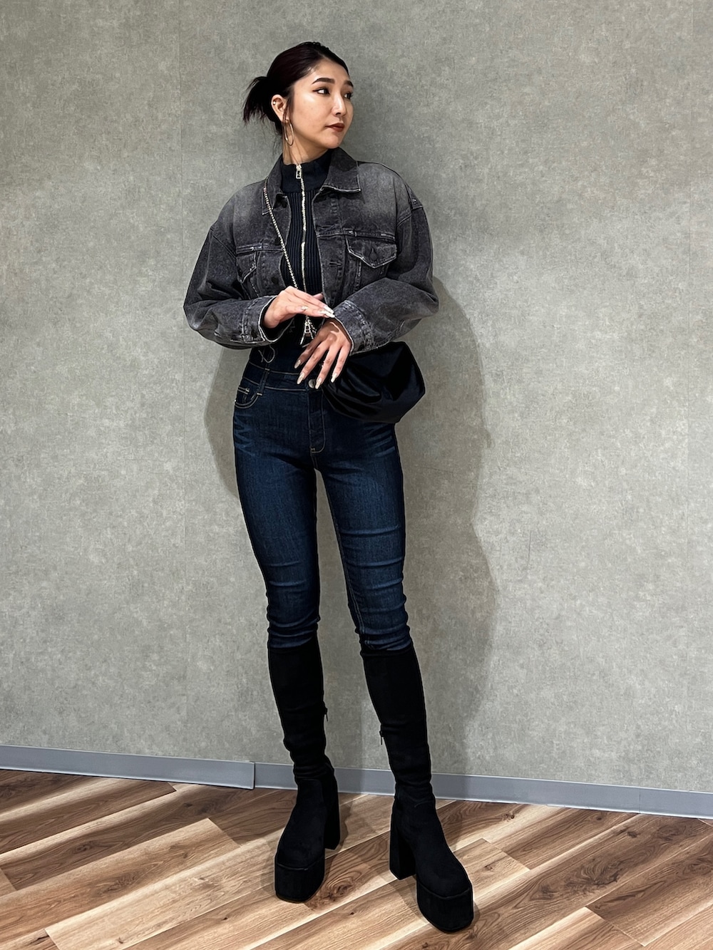 ブラック系のニット/セーター、ブラック系のデニムジャケット、ブルー系のデニムパンツを着用したレディースの秋コーディネートの2枚目の写真