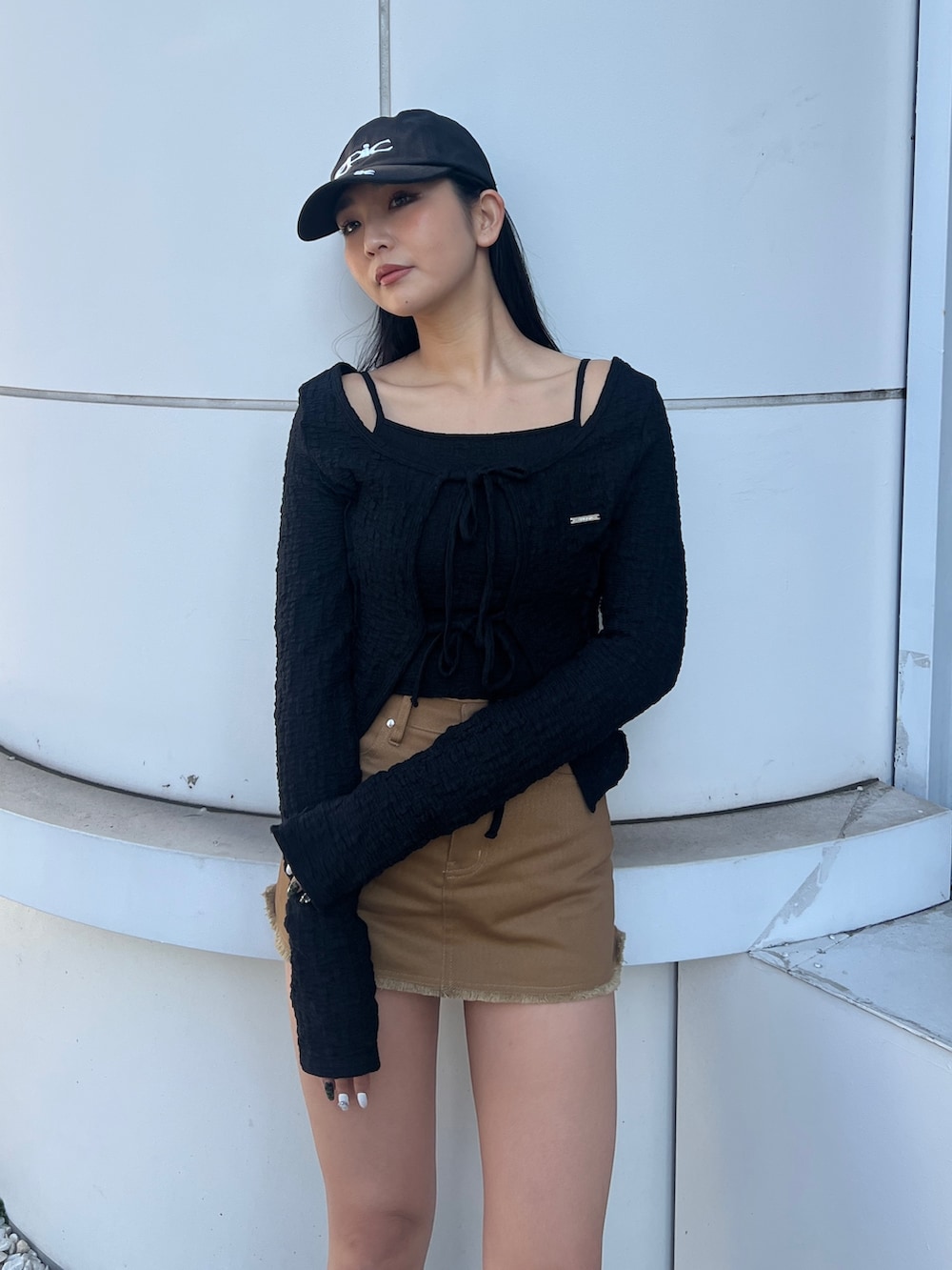 ブラック系のTシャツ/カットソー、ブラウン系のブーツ、ブラック系のキャップを着用したレディースの冬コーディネートの4枚目の写真