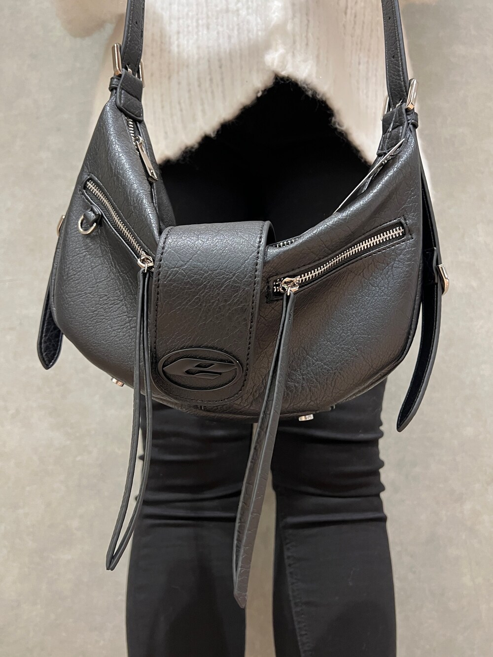 ホワイト系のニット/セーター、ブラック系のデニムパンツ、ブラック系のハンドバッグを着用したレディースの冬コーディネートの7枚目の写真