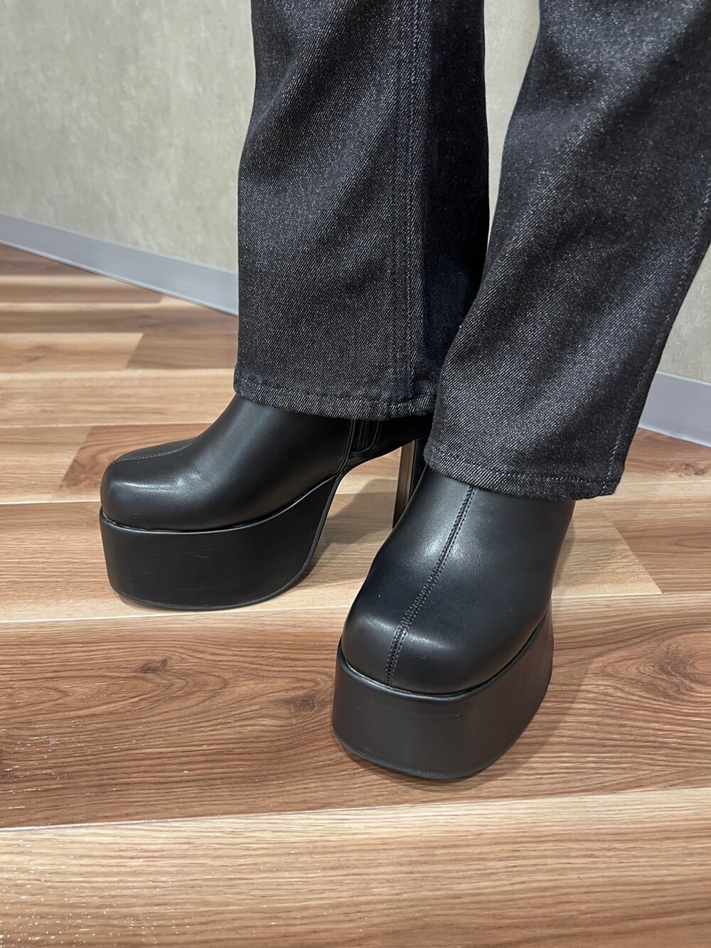 ブラック系のデニムパンツ、ブラック系のブーツ、グレー系のニット/セーターを着用したレディースの秋コーディネートの6枚目の写真