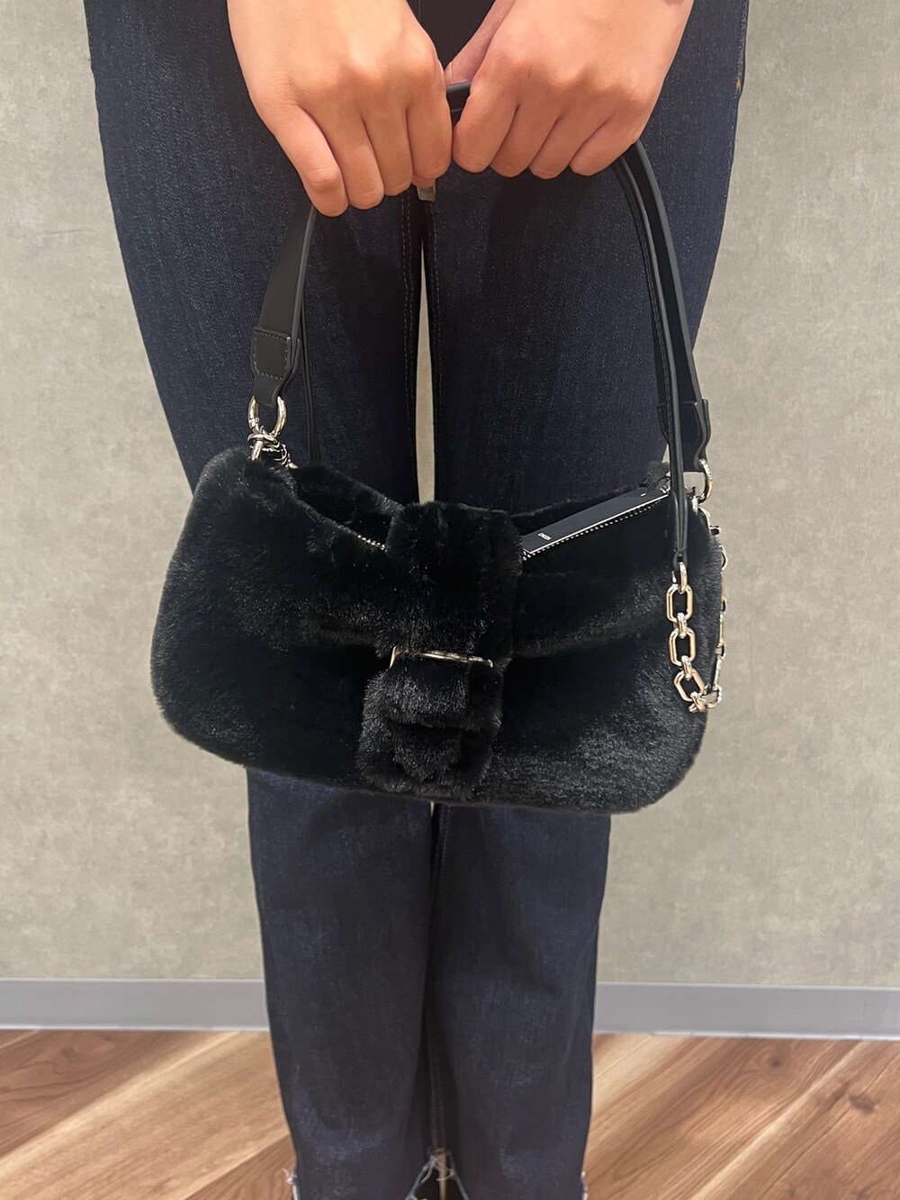 グレー系のニット/セーター、ブルー系のデニムパンツ、ブラック系のハンドバッグを着用したレディースの秋コーディネートの8枚目の写真