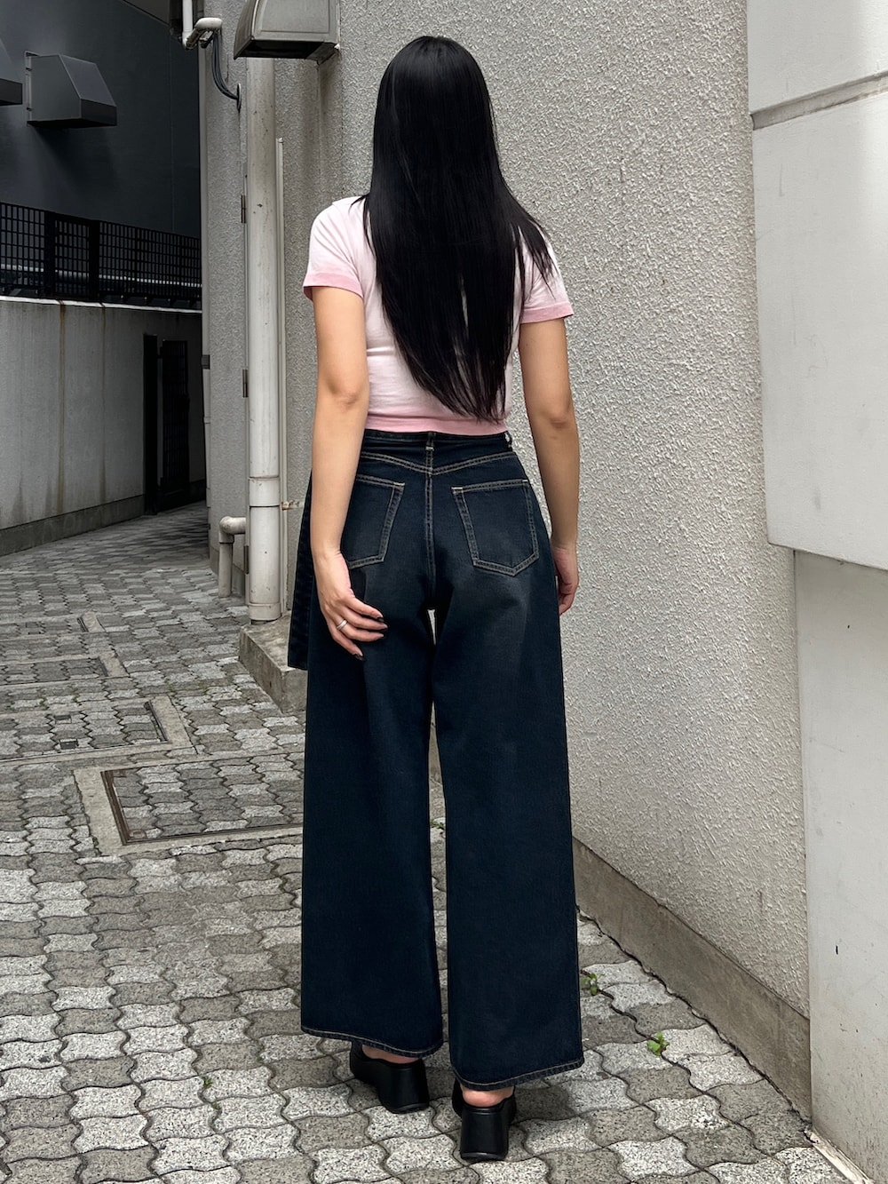 ピンク系のTシャツ/カットソー、ブルー系のデニムパンツ、ブラック系のサンダルを着用したレディースの夏コーディネートの3枚目の写真