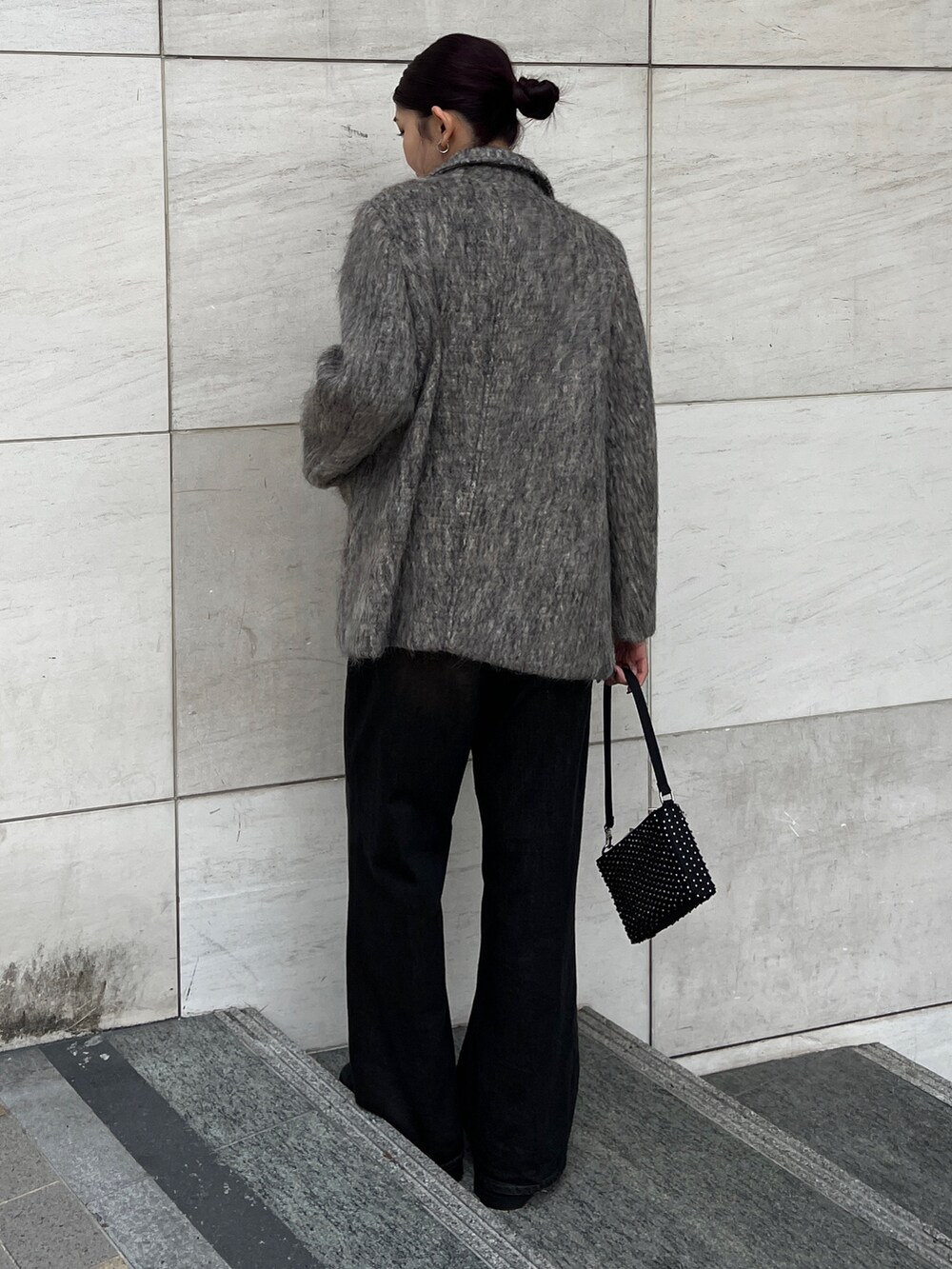 ブラック系のデニムパンツ、ブラック系のブーツ、ベージュ系のテーラードジャケットを着用したレディースの冬コーディネートの3枚目の写真