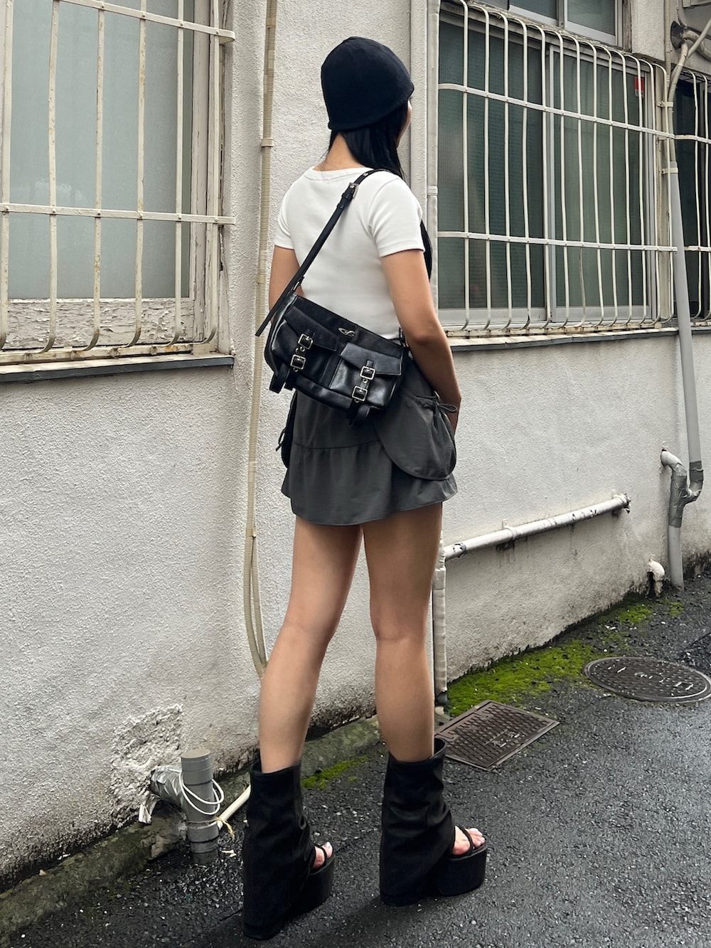 ホワイト系のTシャツ/カットソー、グレー系のスカート、ブラック系のサンダルを着用したレディースの夏コーディネートの2枚目の写真