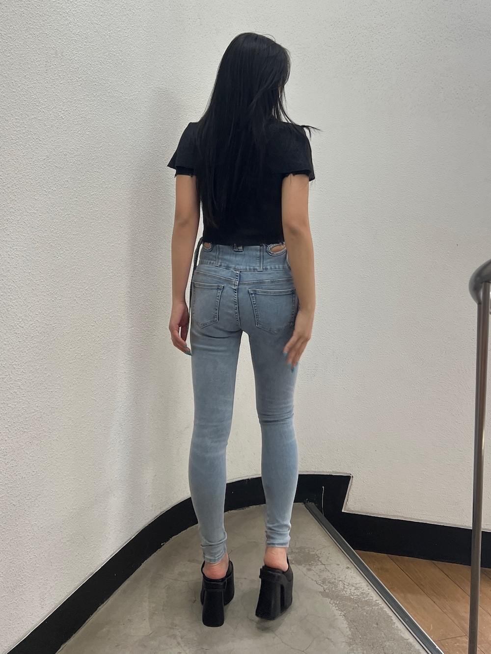 ブラック系のニット/セーター、ブルー系のデニムパンツ、ブラック系のサンダルを着用したレディースの春コーディネートの4枚目の写真