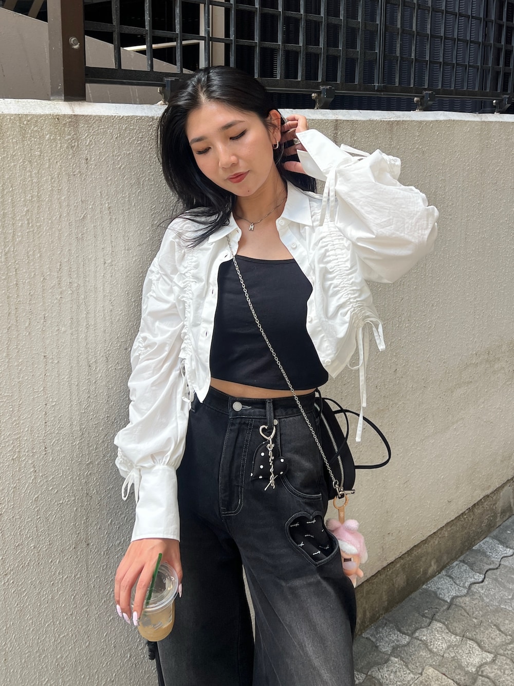 ホワイト系のシャツ/ブラウス、ブラック系のデニムパンツ、ブラック系のハンドバッグを着用したレディースの夏コーディネートの3枚目の写真