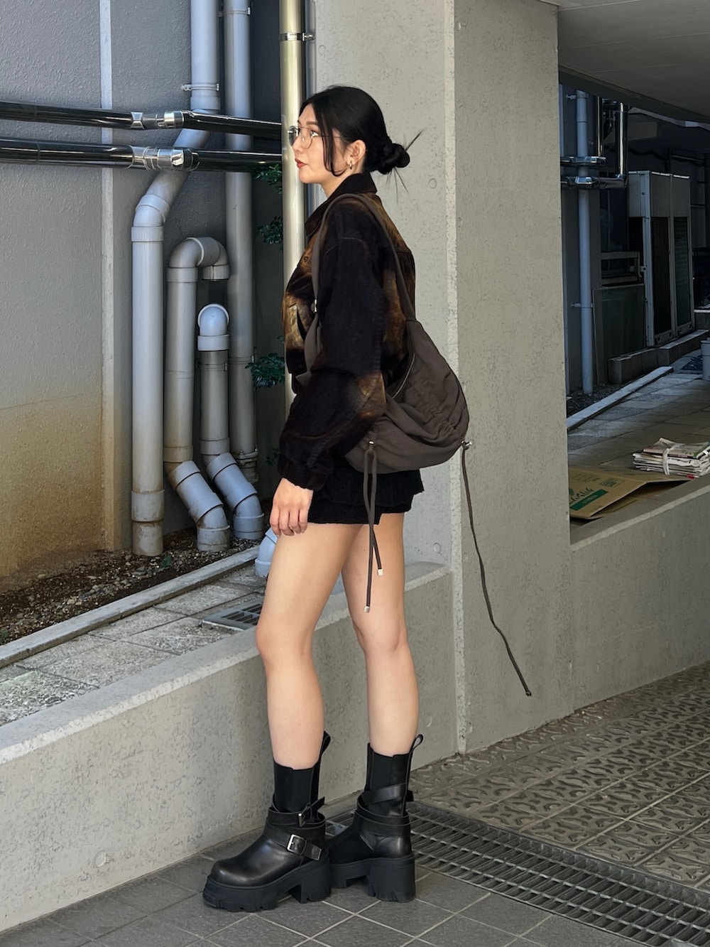 ブラウン系のブルゾン、ブラック系のスカート、ブラック系のブーツを着用したレディースの夏コーディネートの2枚目の写真