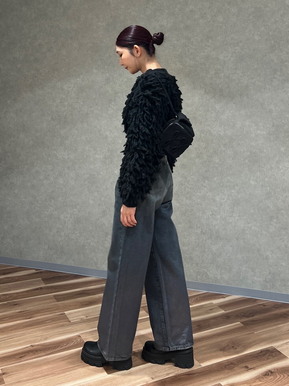 ブラック系のニット/セーター、ブルー系のデニムパンツ、ブラック系のブーツを着用したレディースの冬コーディネートの3枚目の写真