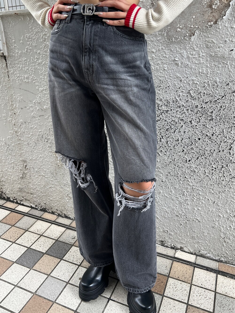 ホワイト系のニット/セーター、グレー系のデニムパンツ、ブラック系のブーツを着用したレディースの秋コーディネートの6枚目の写真