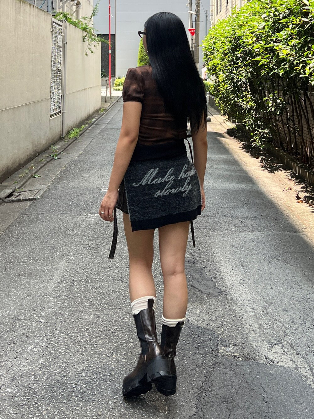 ブラウン系のTシャツ/カットソー、ブルー系のスカート、ブラウン系のブーツを着用したレディースの夏コーディネートの3枚目の写真