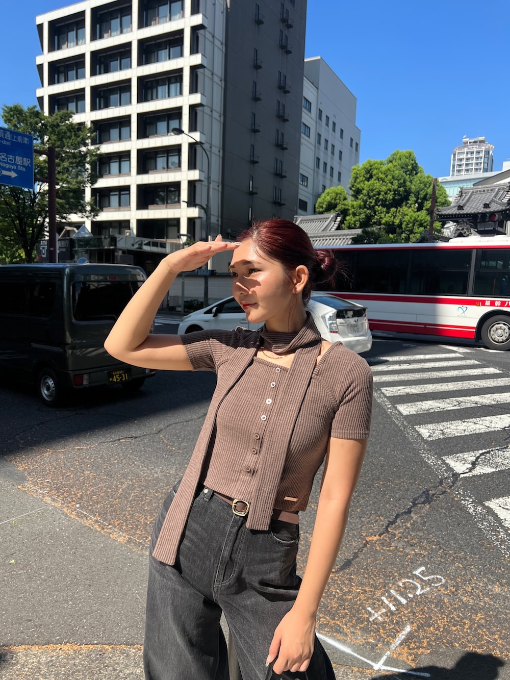 ブラウン系のTシャツ/カットソー、ブラック系のデニムパンツ、ブラック系のショルダーバッグを着用したレディースの夏コーディネートの5枚目の写真