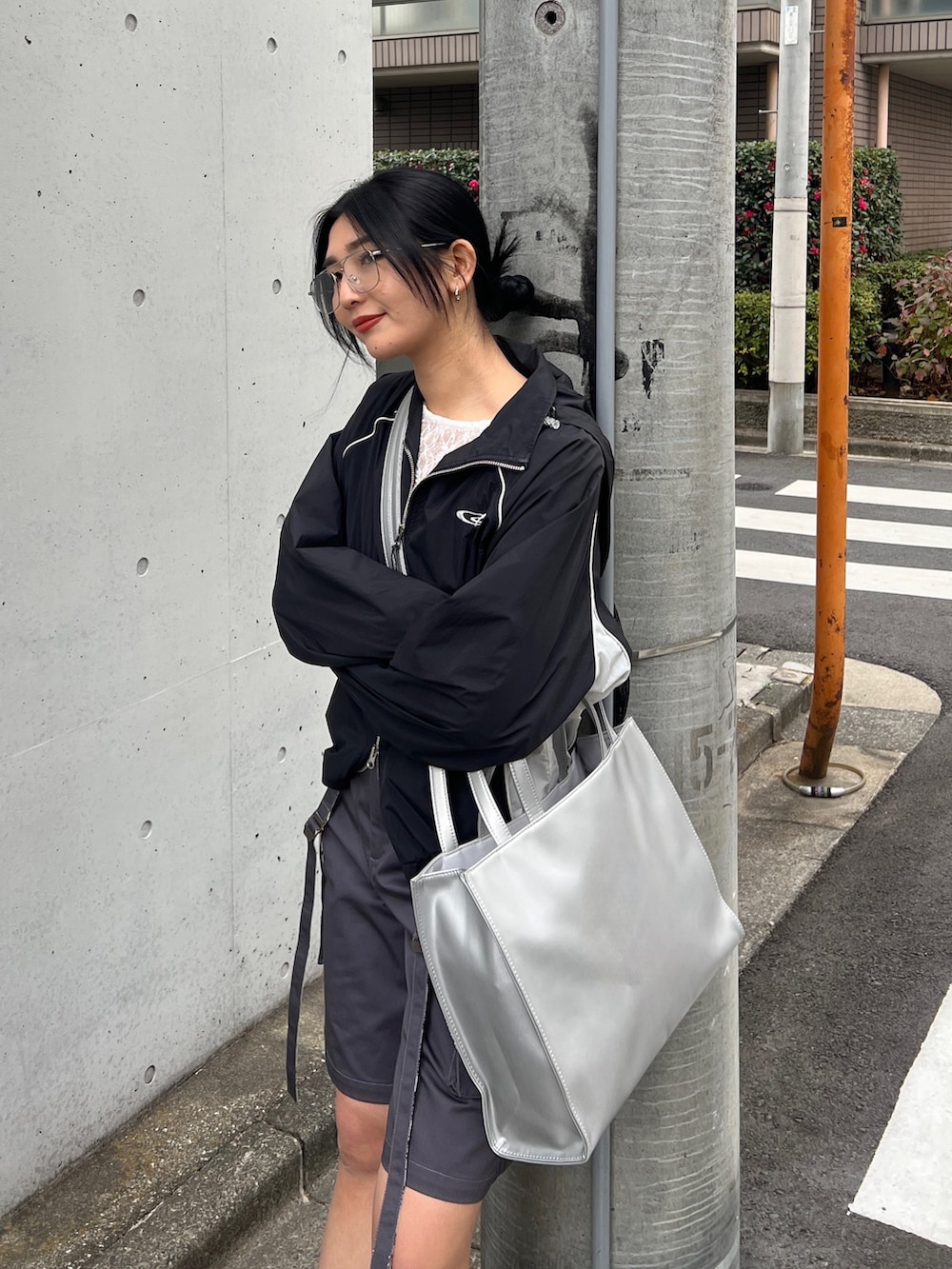 ブラック系のブルゾン、ホワイト系のTシャツ/カットソー、シルバー系のスニーカーを着用したレディースの春コーディネートの4枚目の写真