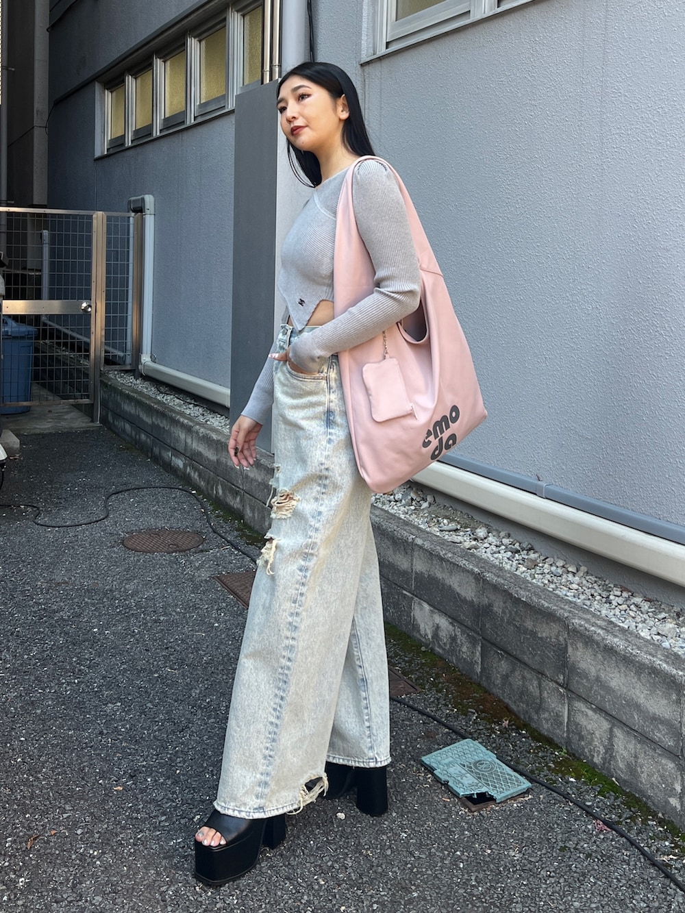 グレー系のニット/セーター、ブルー系のデニムパンツ、ブラック系のサンダルを着用したレディースの冬コーディネートの2枚目の写真