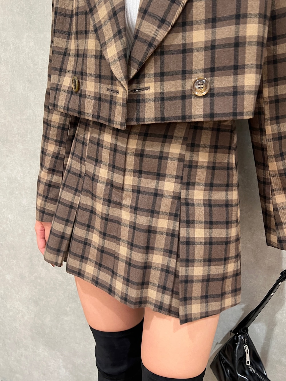 その他のテーラードジャケット、ブラック系のブーツ、ホワイト系のニット/セーターを着用したレディースの秋コーディネートの5枚目の写真