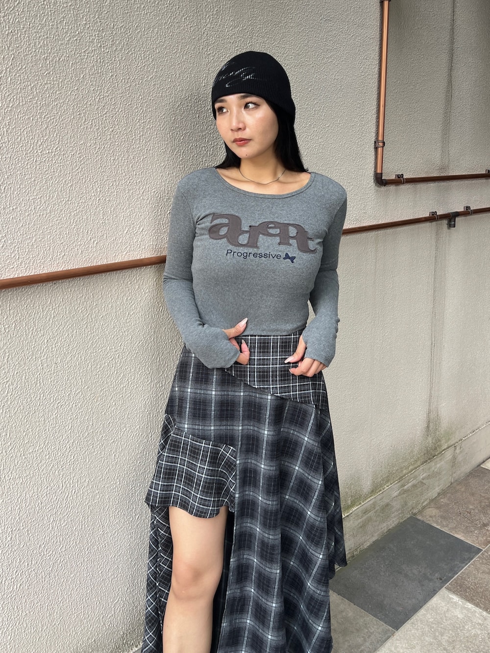 グレー系のTシャツ/カットソー、ブラック系のスカート、ブラック系のブーツを着用したレディースの秋コーディネートの2枚目の写真