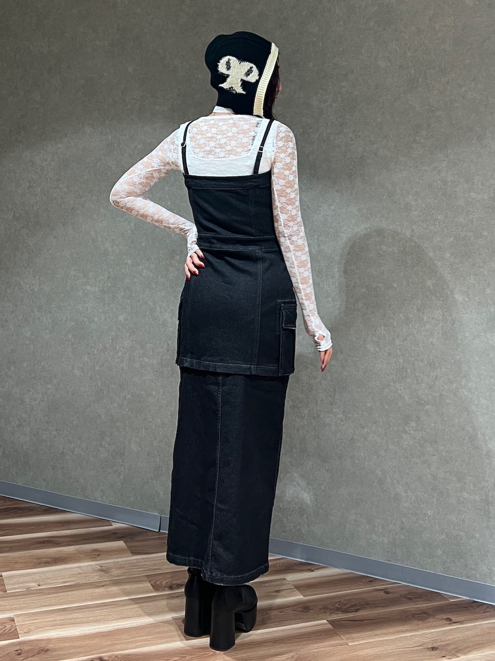 ブラック系のワンピース、ホワイト系のTシャツ/カットソー、ブラック系のブーツを着用したレディースの秋コーディネートの3枚目の写真