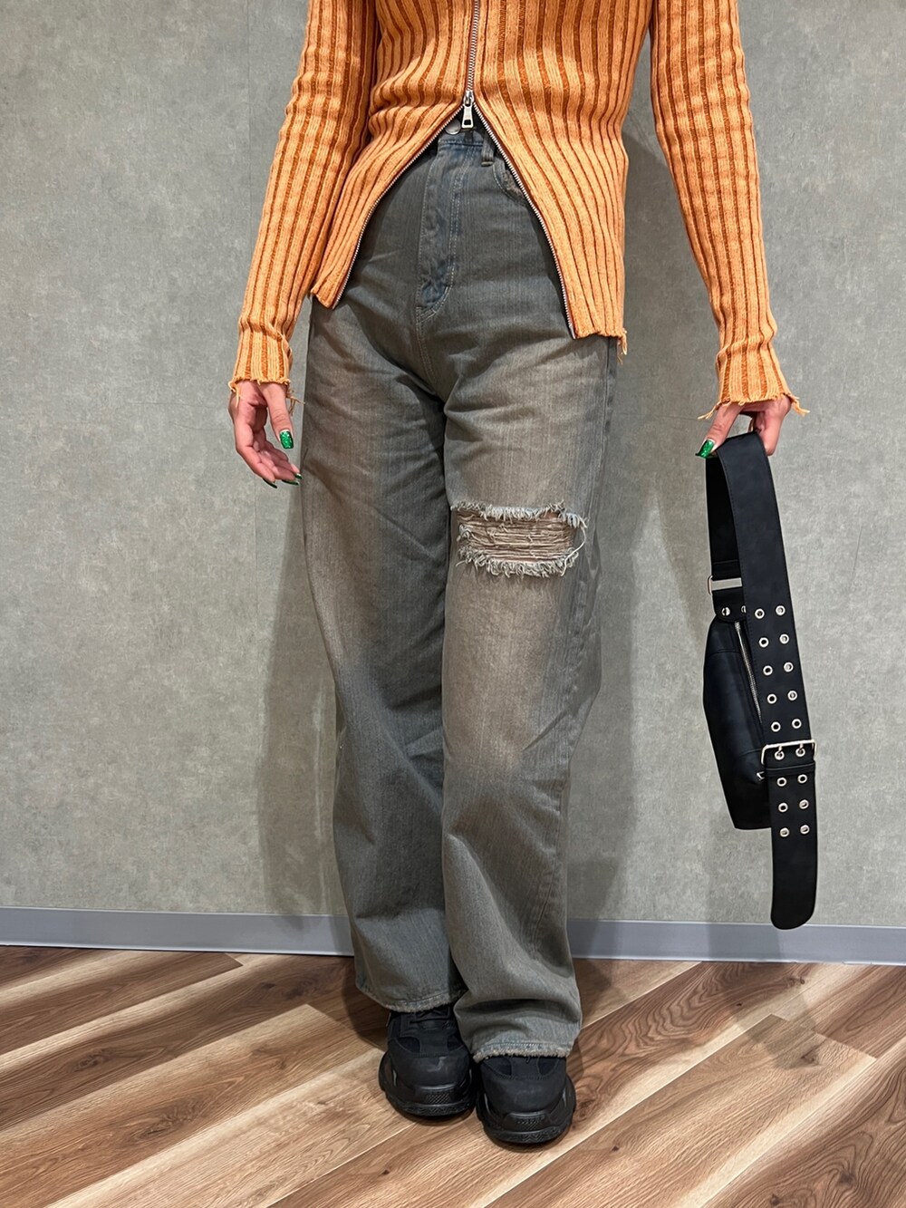 オレンジ系のニット/セーター、グレー系のデニムパンツ、ブラック系のショルダーバッグを着用したレディースの冬コーディネートの5枚目の写真