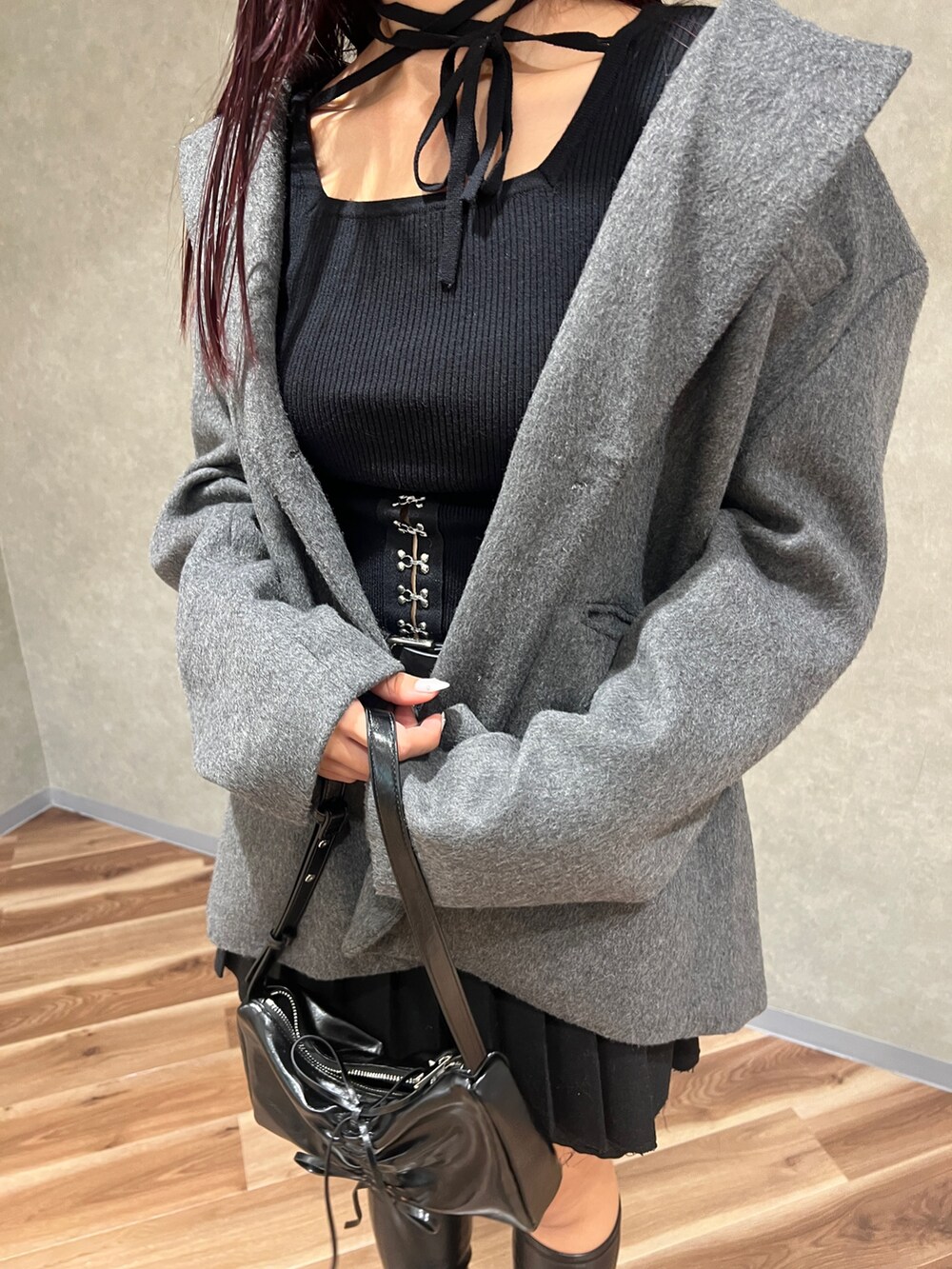 ブラック系のニット/セーター、グレー系のテーラードジャケット、ブラック系のスカートを着用したレディースの秋コーディネートの5枚目の写真