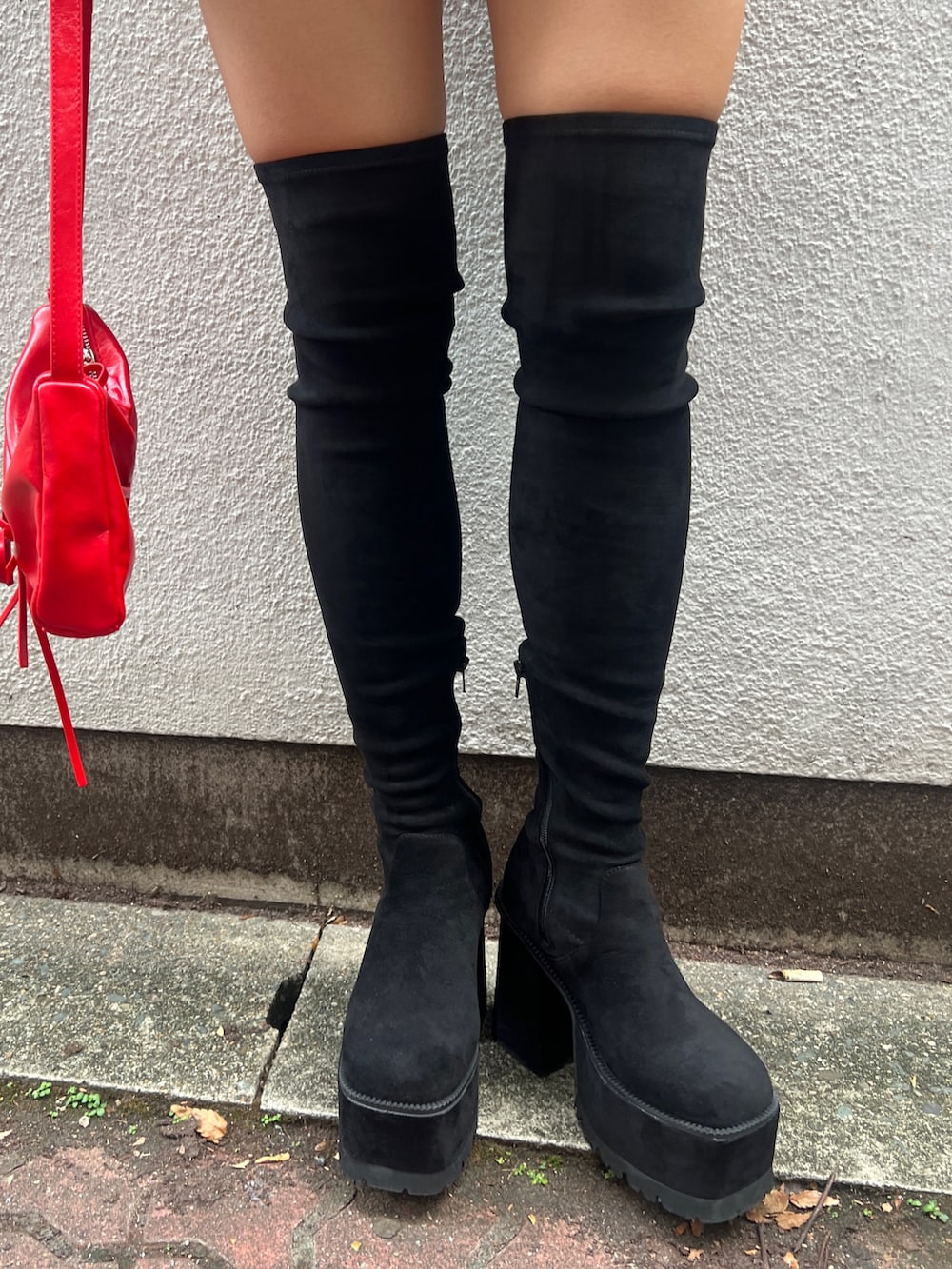 ブルー系のニット/セーター、ブラック系のその他パンツ、ブラック系のブーツを着用したレディースの秋コーディネートの6枚目の写真