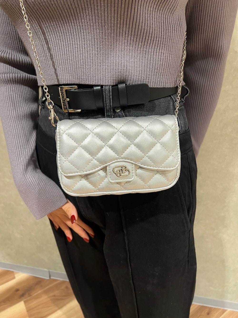 グレー系のニット/セーター、ブラック系のデニムパンツ、ブラック系のブーツを着用したレディースの冬コーディネートの5枚目の写真