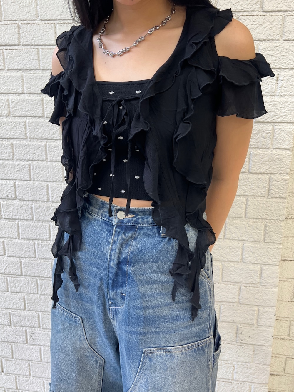 ブラック系のTシャツ/カットソー、ブラック系のニット/セーター、ブルー系のデニムパンツを着用したレディースの夏コーディネートの4枚目の写真