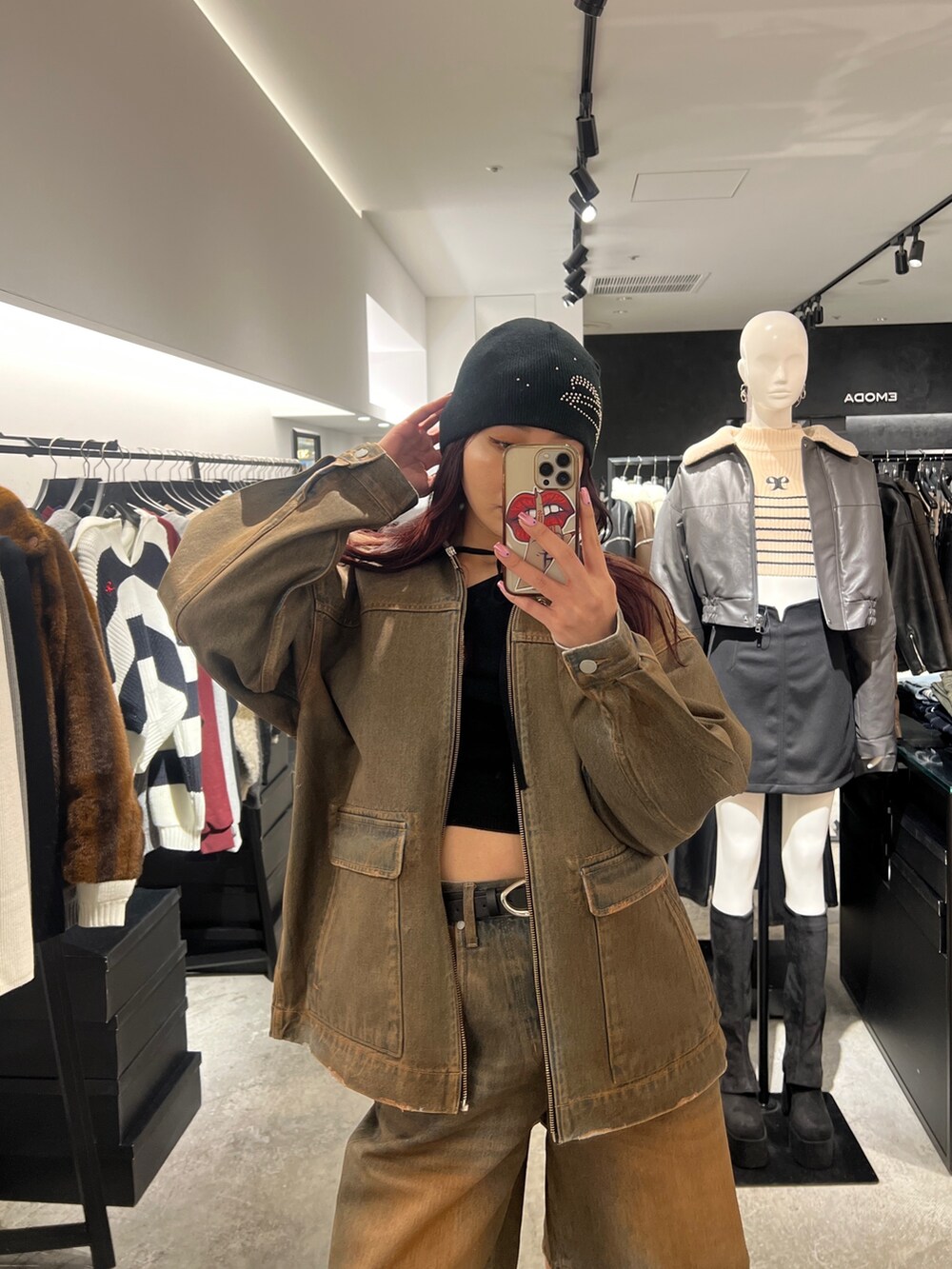 ブラック系のデニムパンツ、ブラック系のブーツ、ブラウン系のブルゾンを着用したレディースの冬コーディネートの4枚目の写真