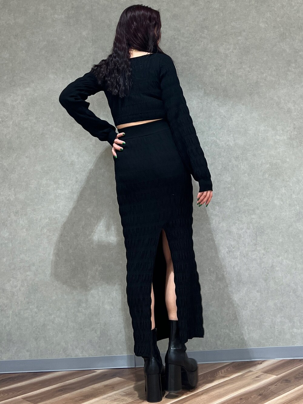 ブラック系のニット/セーター、ブラック系のスカート、ブラック系のブーツを着用したレディースの冬コーディネートの2枚目の写真