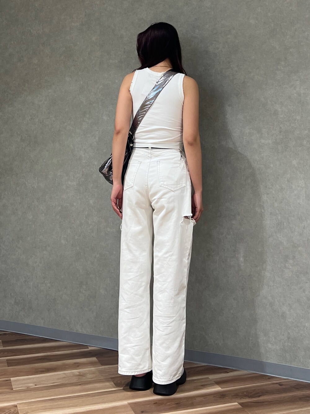 ホワイト系のタンクトップ、ホワイト系のデニムパンツ、シルバー系のハンドバッグを着用したレディースの夏コーディネートの3枚目の写真