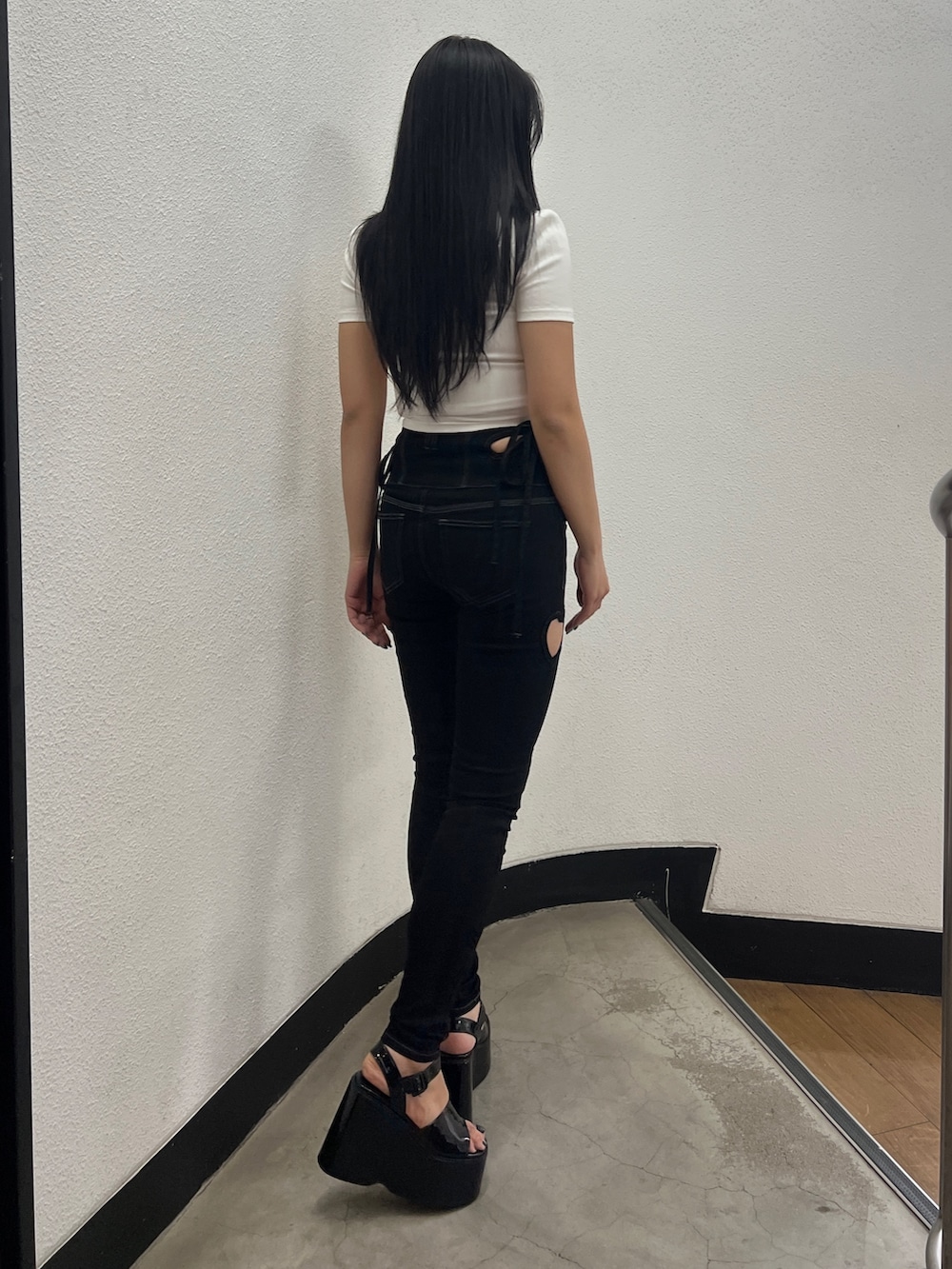 ホワイト系のTシャツ/カットソー、ブラック系のデニムパンツ、ブラック系のサンダルを着用したレディースの春コーディネートの2枚目の写真