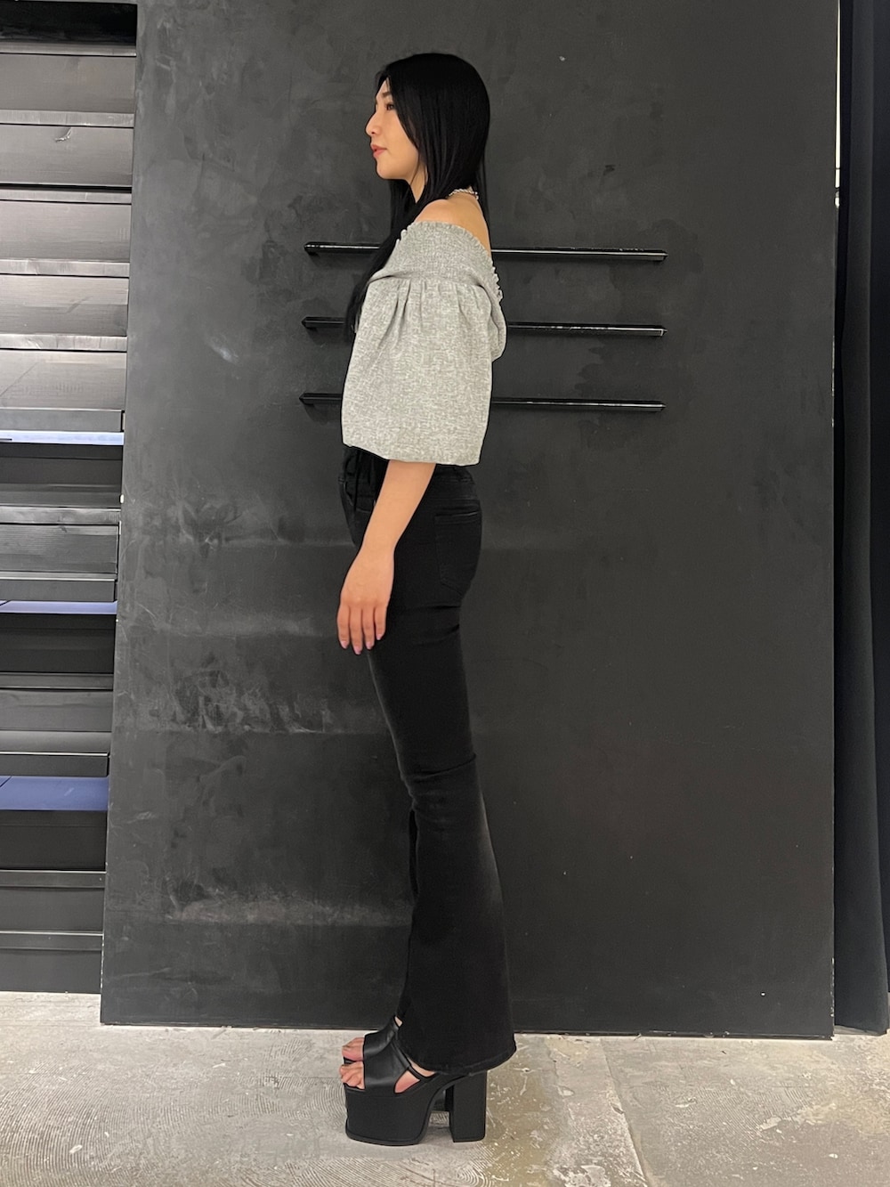 ブラック系のデニムパンツ、ブラック系のサンダル、グレー系のTシャツ/カットソーを着用したレディースの春コーディネートの3枚目の写真