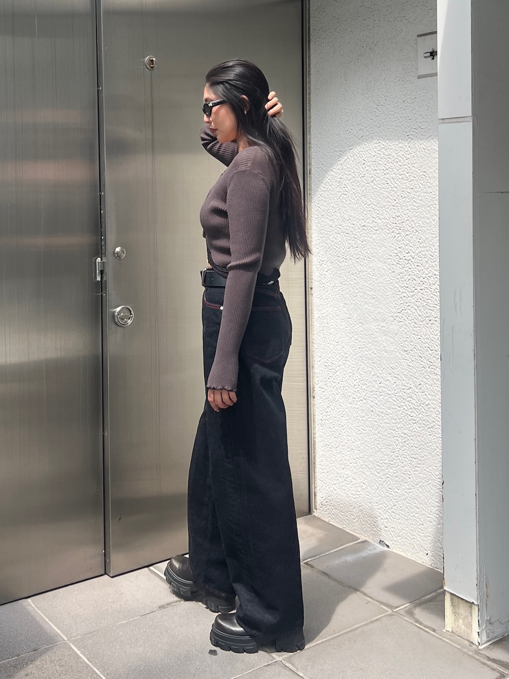 グリーン系のニット/セーター、ブルー系のデニムパンツ、ブラック系のブーツを着用したレディースの秋コーディネートの2枚目の写真