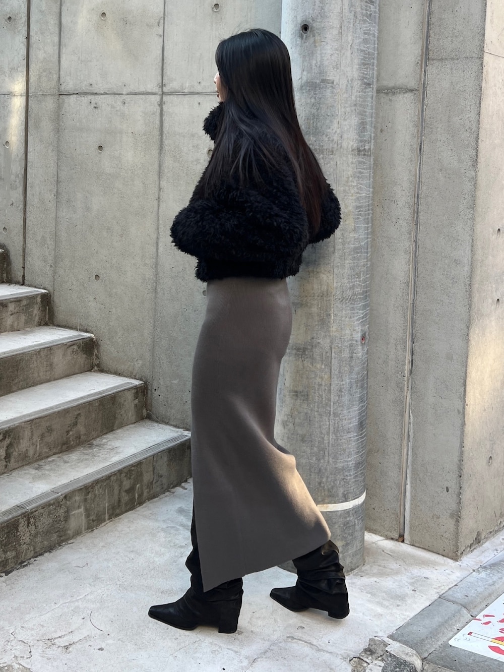 ブラック系のブルゾン、グレー系のワンピース、ブラック系のブーツを着用したレディースの冬コーディネートの2枚目の写真