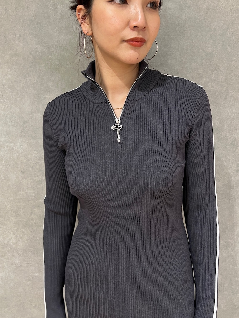 グレー系のワンピース、ブラック系のブルゾン、ブラック系のブーツを着用したレディースの冬コーディネートの5枚目の写真