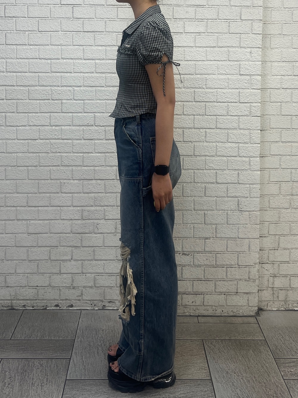 ブラック系のシャツ/ブラウス、ブルー系のデニムパンツ、ブラック系のサンダルを着用したレディースの春コーディネートの3枚目の写真